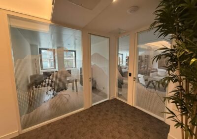 Vitrophanie décorative pour bureaux à Genève, design perforé pour intimité visuelle.