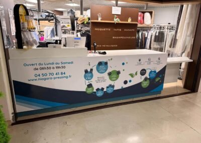Habillage adhésif de comptoir pour le pressing Niagara à Thonon-les-Bains, impression grand format et pose professionnelle.