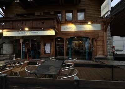 Enseigne non lumineuse installée sur la façade en bois d’un restaurant à Megève.